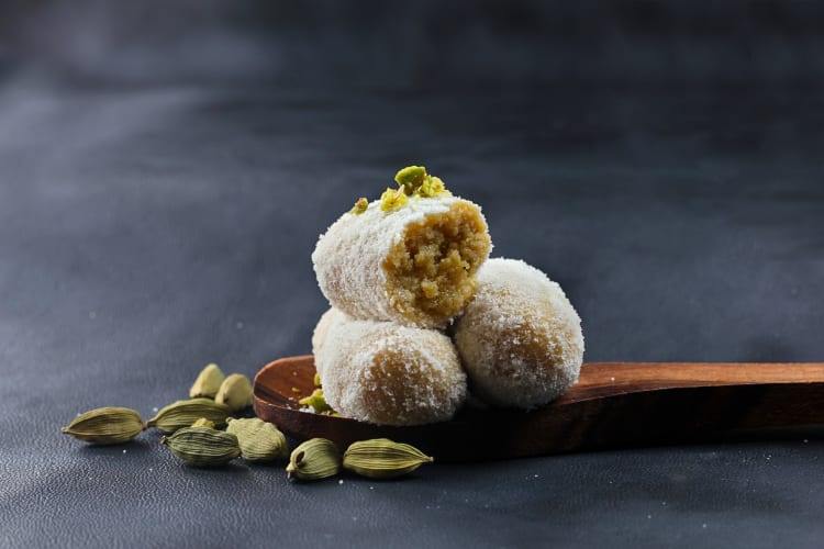Three portions of dharwad peda on a wooden spoon