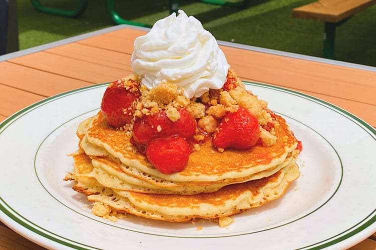 Pancakes topped with strawberries, crumble and cream, from Dilly Diner