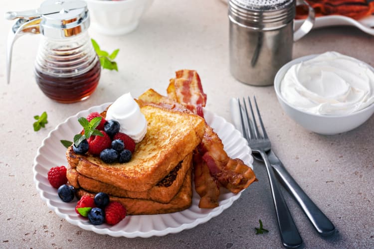 French toast with bacon, berries, cream and maple syrup.