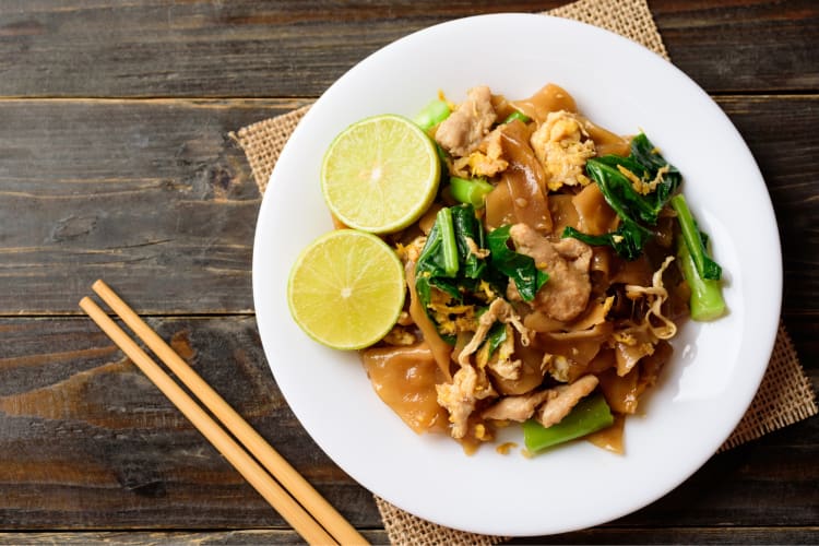 A plate of noodles with lime