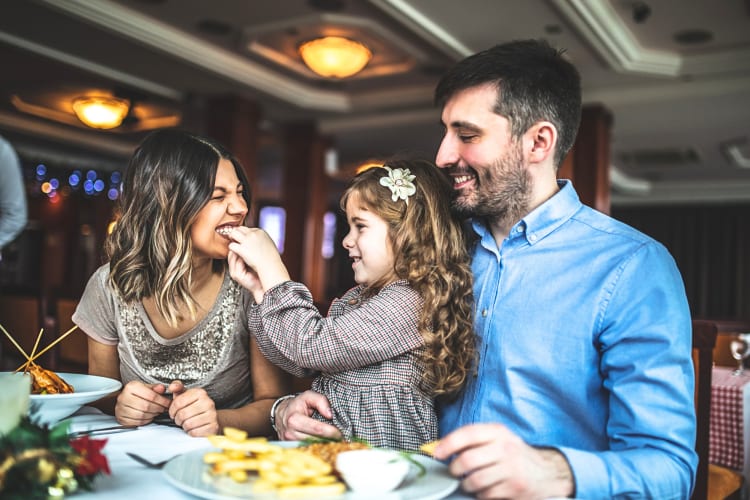 Mother, father and daughter having a meal at a restaurant
