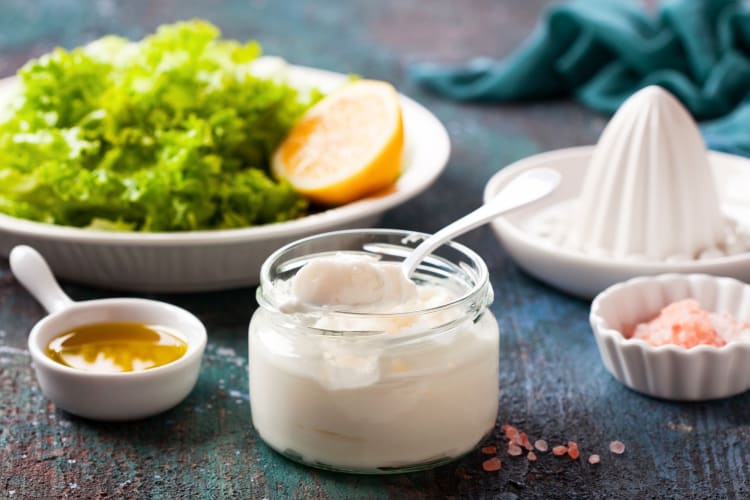 A jar of mayonnaise next to a salad