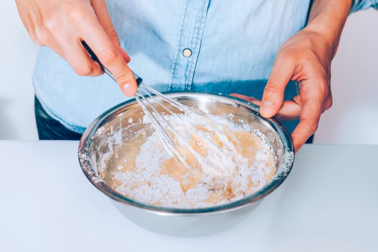 A person mixing a batter