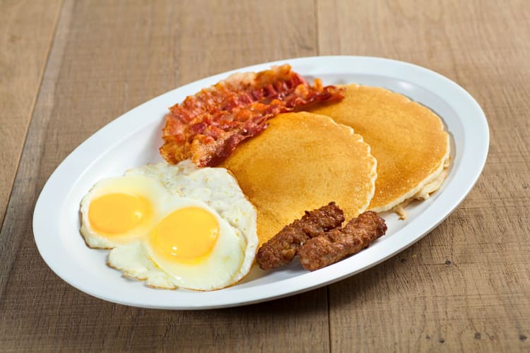 Breakfast meal with eggs, pancakes, bacon and sausages