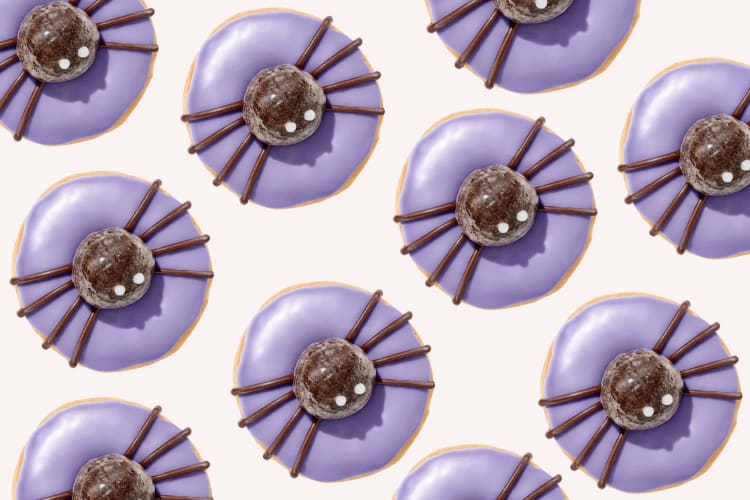 Multiple spider donuts from the Dunkin' Halloween menu on a beige background
