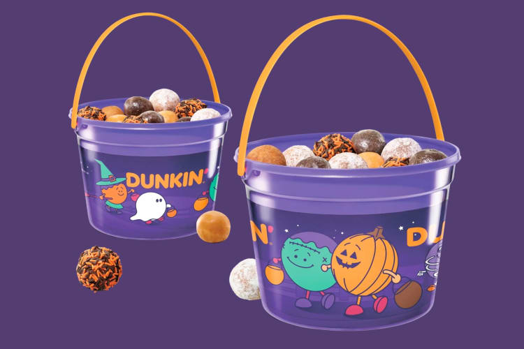 A purple bucket with Halloween design filled with mini donuts