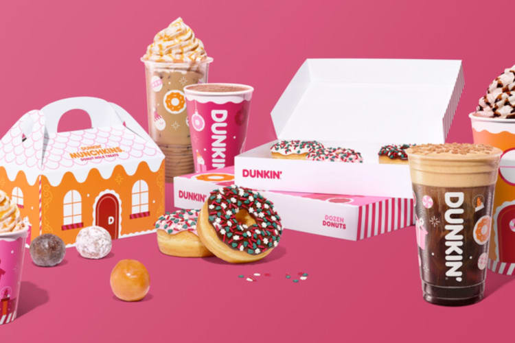 Dunkin' Donuts holiday drinks and food on a pink background