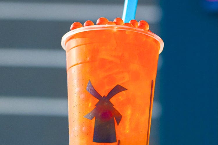 An orange drink with boba on top