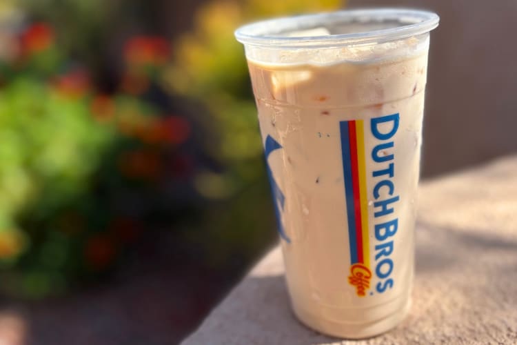 A coffee with milk in a clear Dutch Bros cup