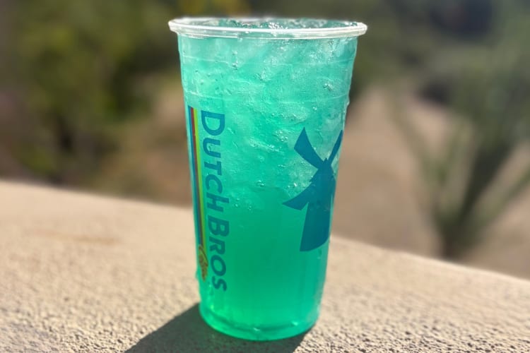 A green-blue drink in a clear Dutch Bros cup