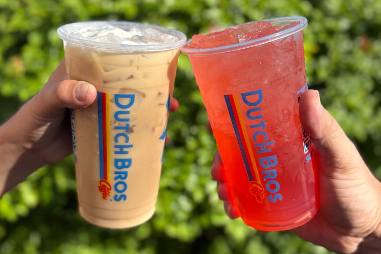 Two people holding a coffee drink and a red energy drink