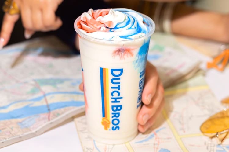 A white milkshake with red and blue sauce in a Dutch Bros cup