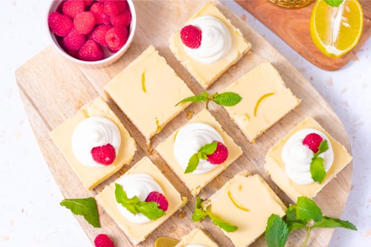 Lemon cheesecake bars decorated with fresh raspberries and mint