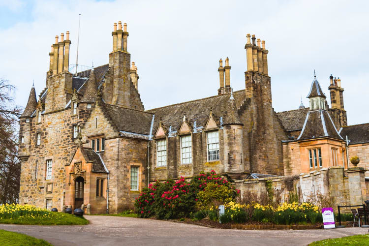 A castle-style building next to a garden