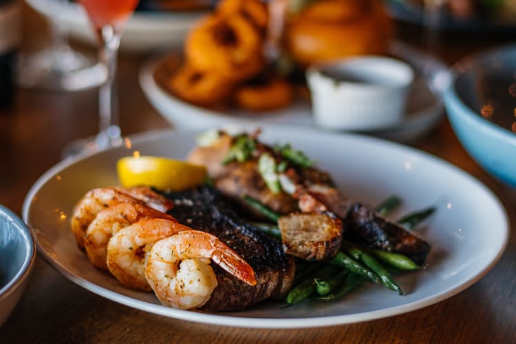 A plate with steak, shrimp and asparagus