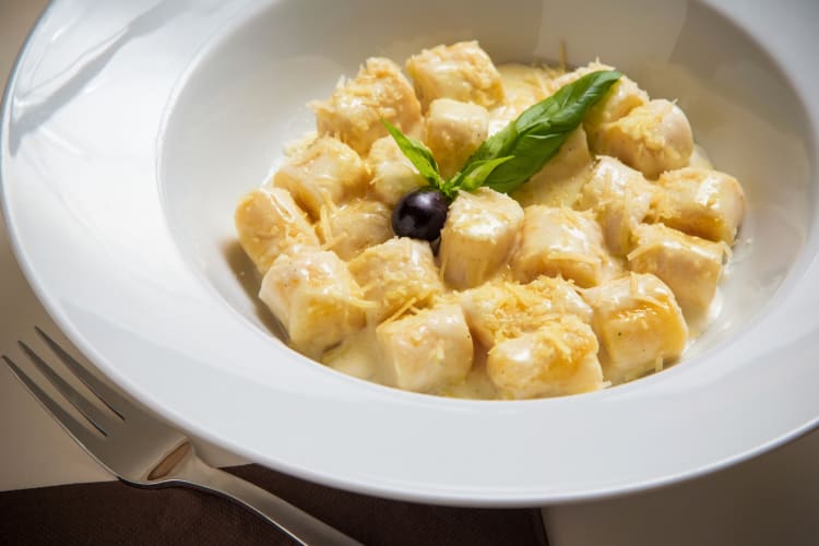 Gnocchi dish with cheese and garnish on top