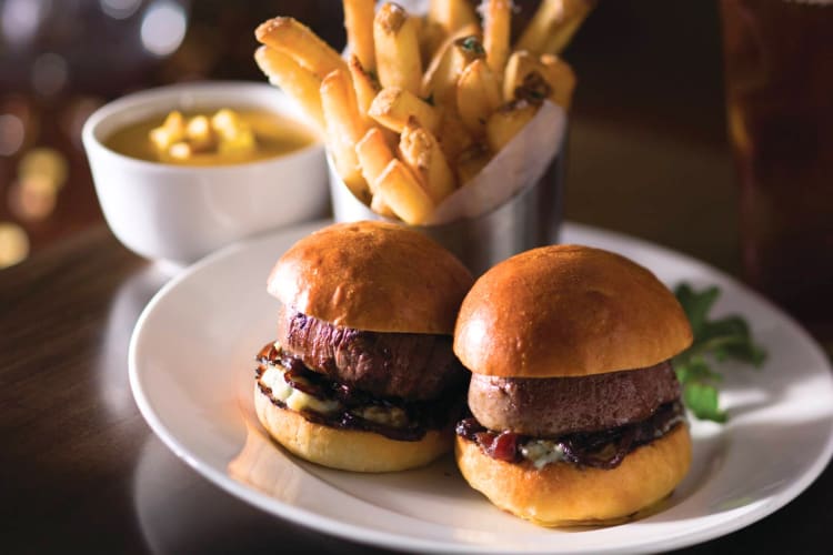 Two mini burgers with fries in the background from The Capital Grille in Boston