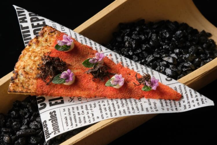 A slice of pizza with edible flowers