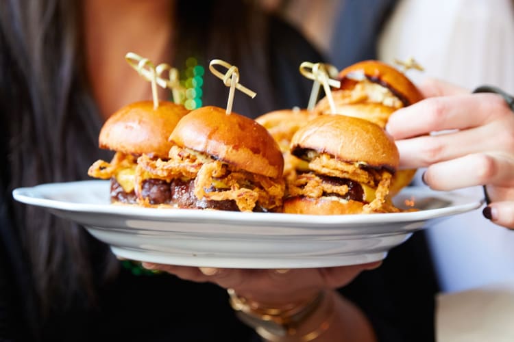 A person taking a slider of of a plate