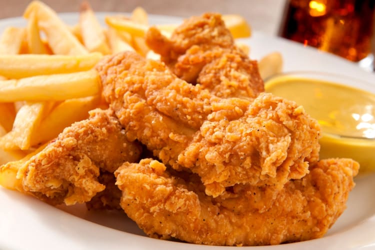 Chicken fingers and fries on a white plate