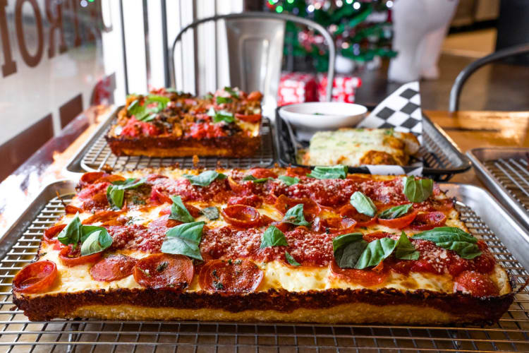 A Detroit-style pizza on a cooling rack on a table