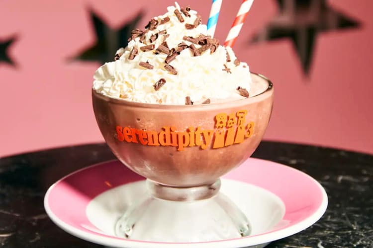 A frozen hot chocolate in a glass on a pink and white plate