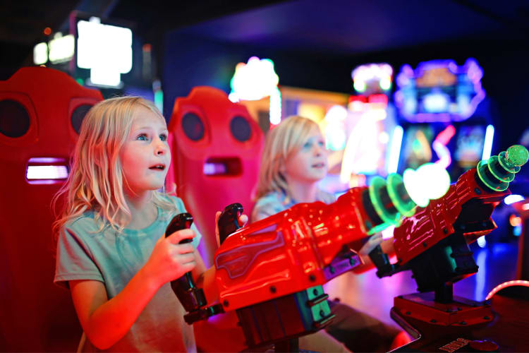 Two kids playing games in an arcade