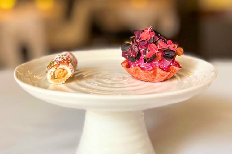 Two canapes on a white ceramic stand