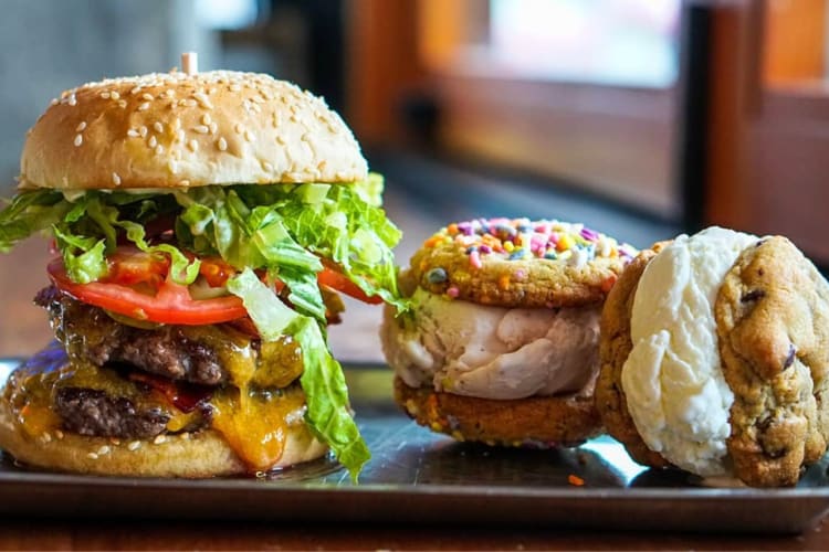 A burger and ice cream sandwiches on a tray