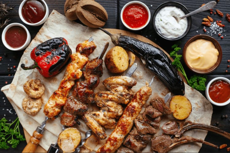 Grilled meat kababs, roasted vegetables and assorted sauces 