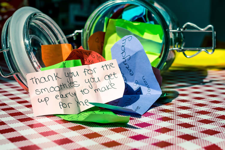Gratitude jar lying on its side, with notes spilling out of it