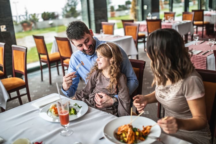 Mother, father and daughter enjoying a meal together at a restaurant