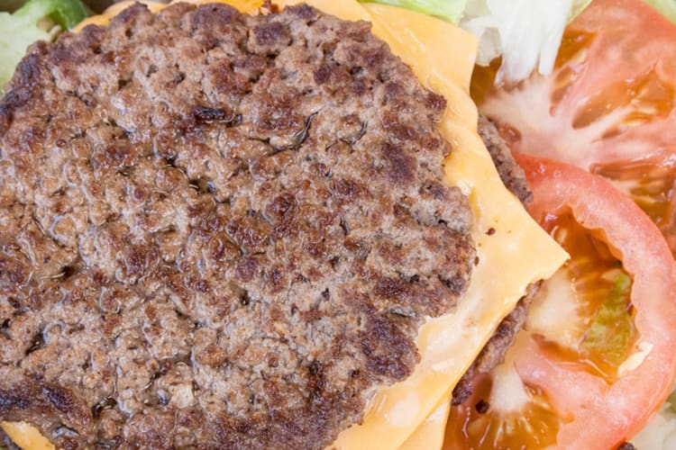 A Five Guys burger salad with beef patty, cheese, tomatoes and lettuce