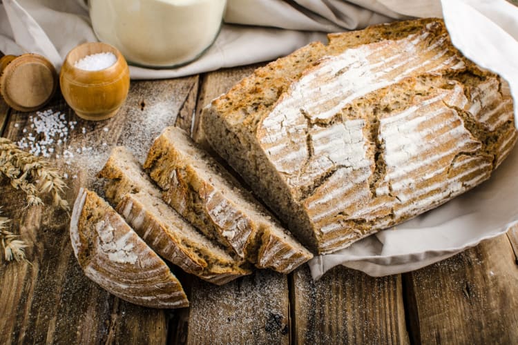 A loaf of homemade bread next to ingredients