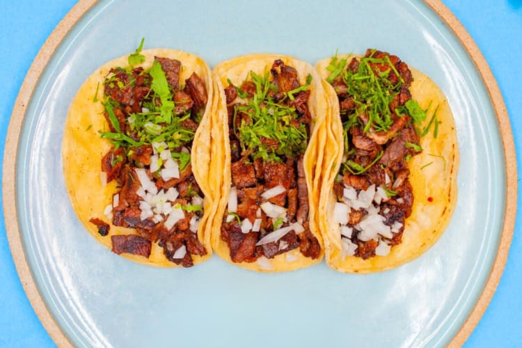 Tacos and radish slices on a blue plate