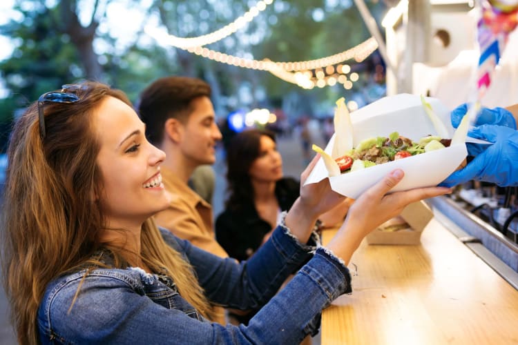 A happy lady receiving her food from a food truck.