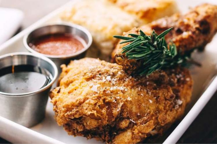 A close-up shot of chicken next to sauces from a restaurant in Savannah, one of the world's best foodie cities
