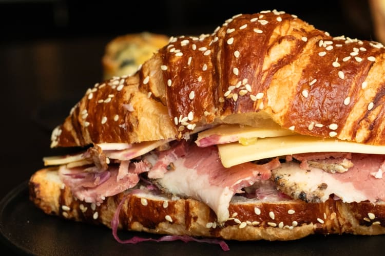 A croissant sandwich with meat and cheese