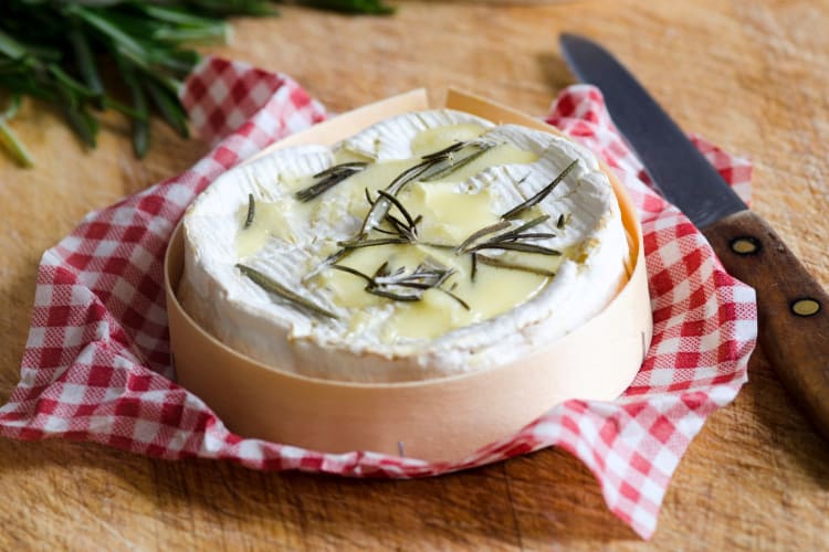 Melted Camembert in a box on a plaid cloth