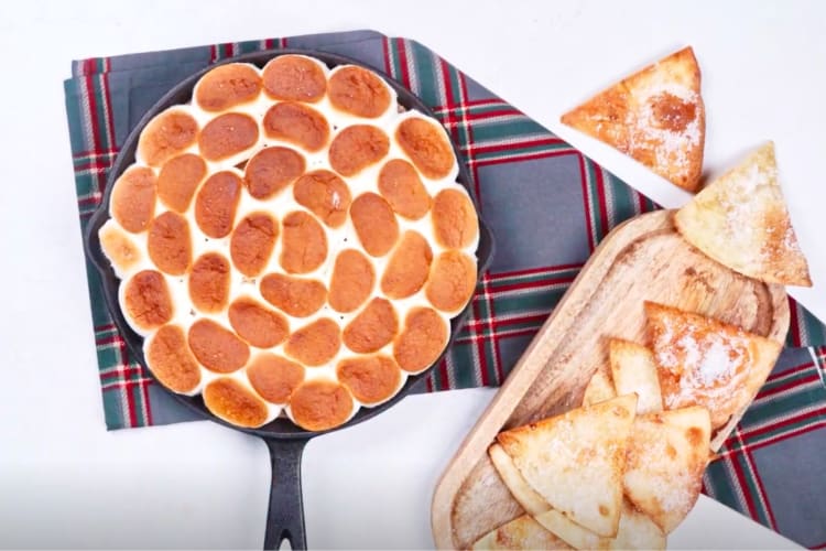 A cast iron pan with marshmallows next to tortilla chips