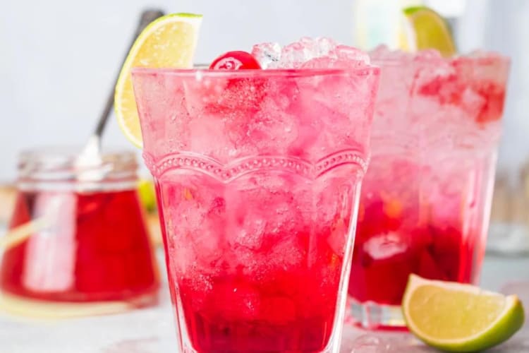 Pink drinks with cherries in glass tumblers