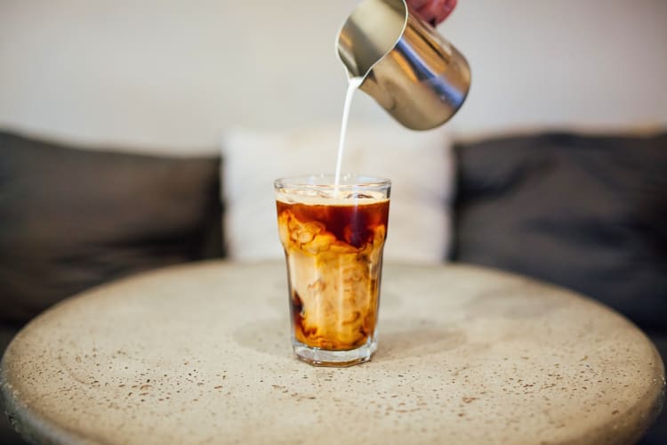 Cold cream brew with milk being poured into it