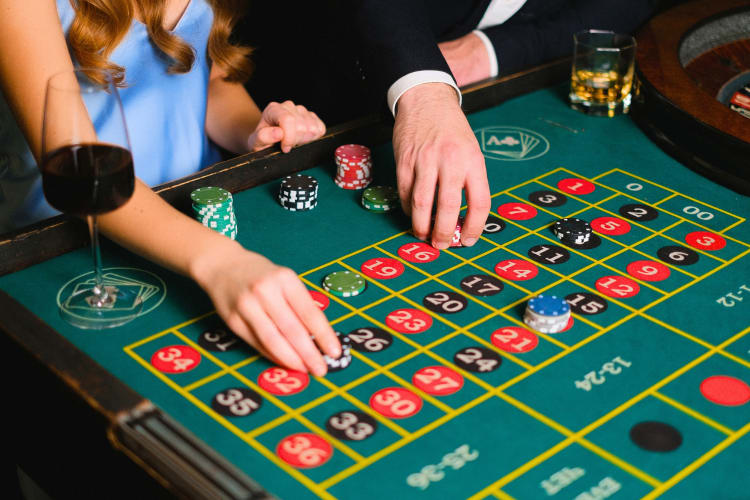 A couple playing a game at a casino table 