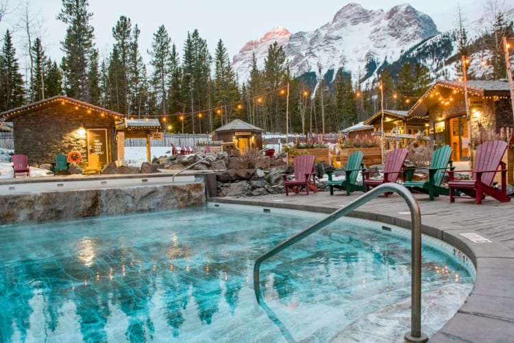 An outdoor pool next to snow-capped mountains