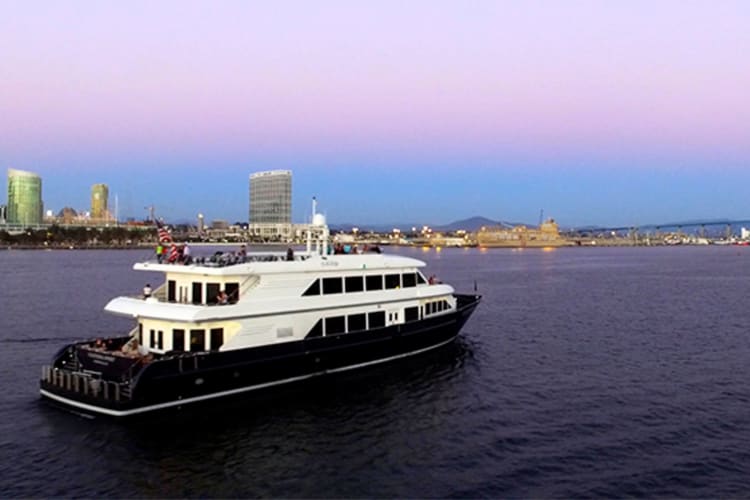 A cruise boat on the water under a purple sky at sunset