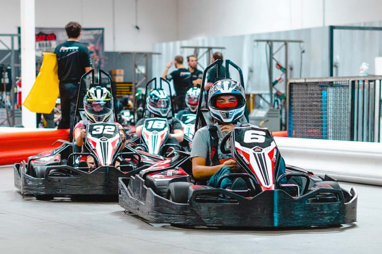 People in go-karts on an indoor track