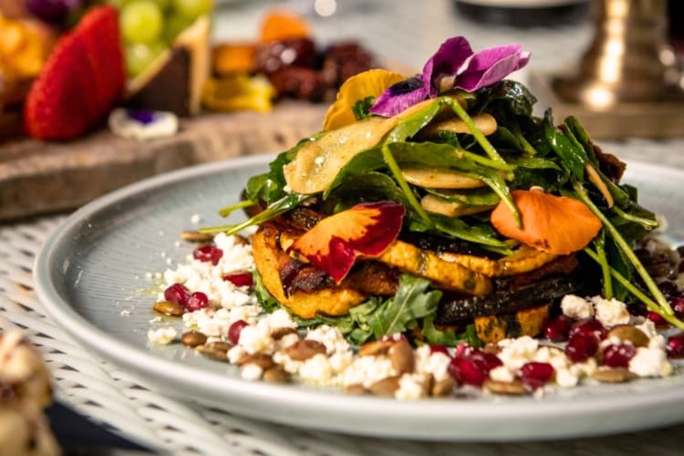 A bowl of salad with colorful edible flowers