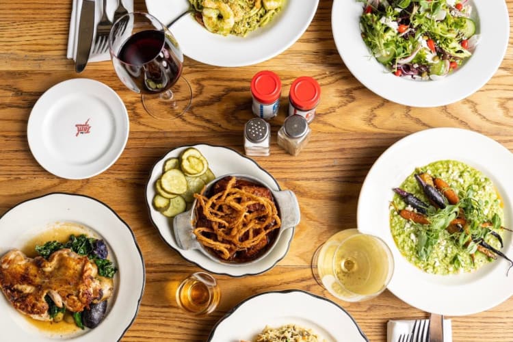 Various dishes and glasses of wine on a wooden table