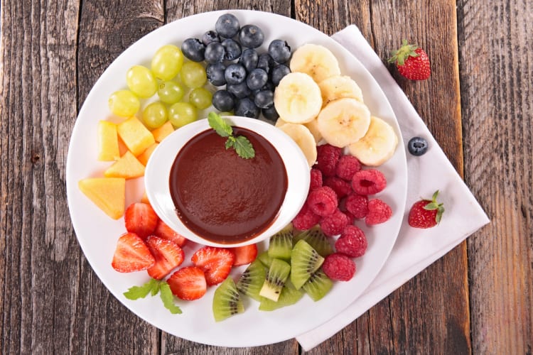 A plate with melted chocolate and fruit