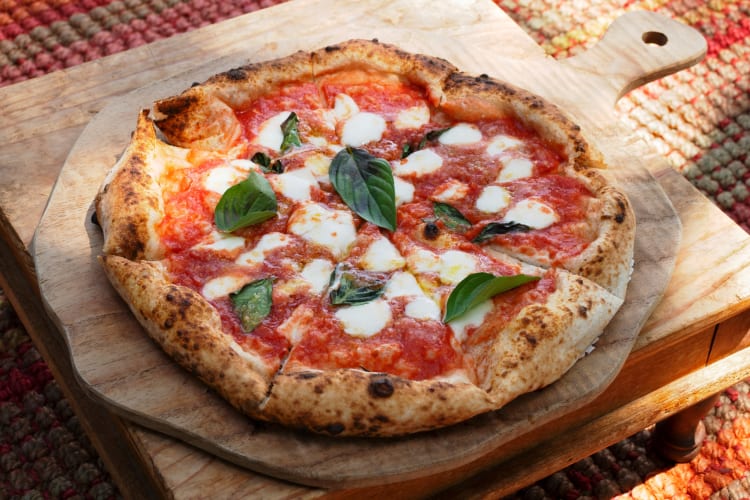 A pizza with tomato, basil and mozzarella